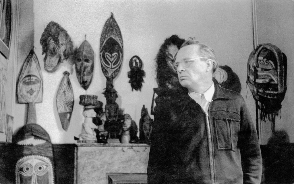 Willi Baumeister vor seiner Sammlung afrikanischer Masken