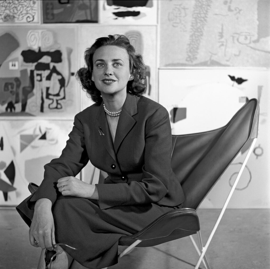 Foto: schwarz-weiß: Krista Gutbrod (geborene Baumeister) vor Bildern von Willi Baumeister