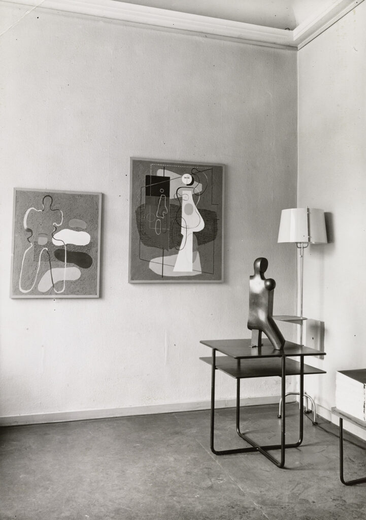 Ansicht einer Ecke mit zwei Bildern an der Wand und Skulptur auf Sockel, Galleria del Milione Mailand, 1935