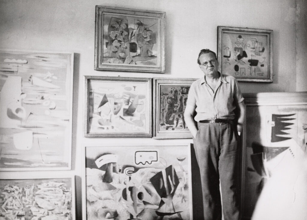 Willi Baumeister vor einer Wand mit Bildern Gerokstraße Stuttgart