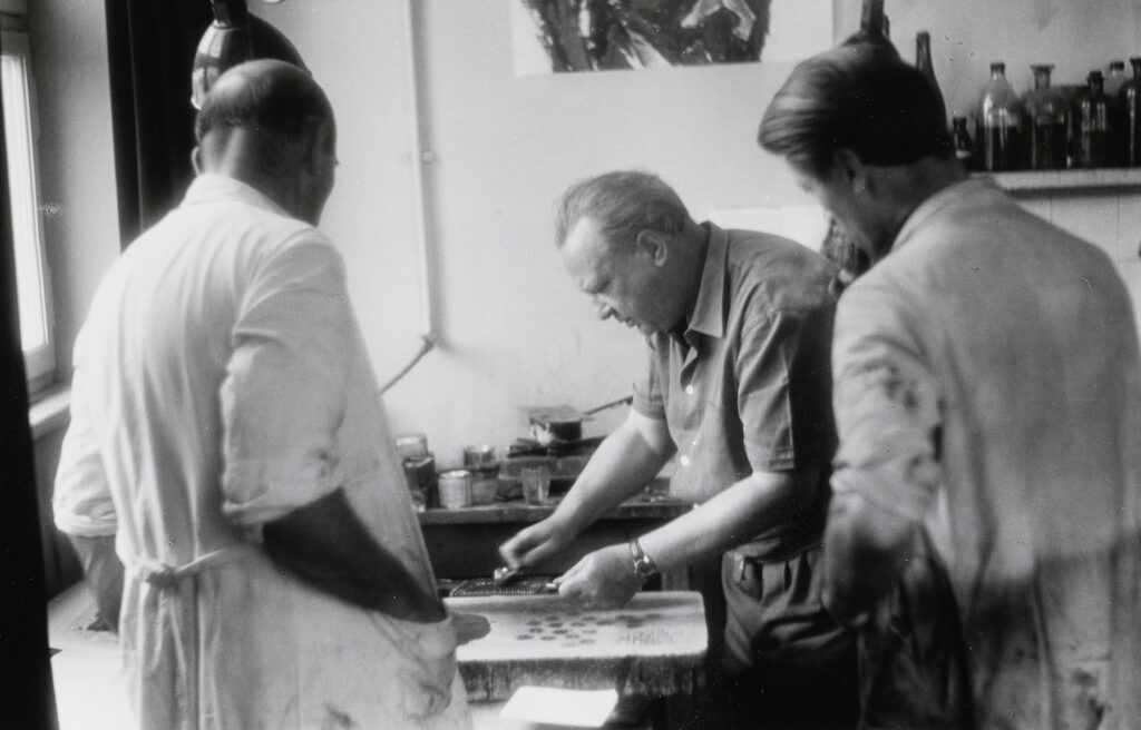 Willi Baumeister am Lithostein arbeitend mit Kollegen