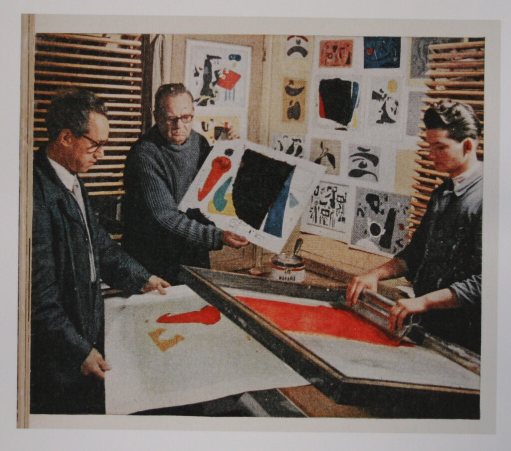 Foto in Farbe: Willi Baumeister mit zwei anderen Personen in der Druckerei Domberger