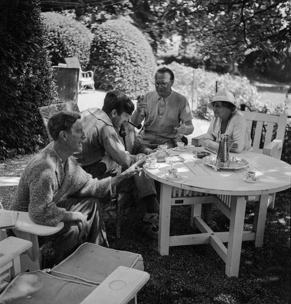 Willi Baumeister gestikulierend am Kaffeetisch mit Kolleg:innen