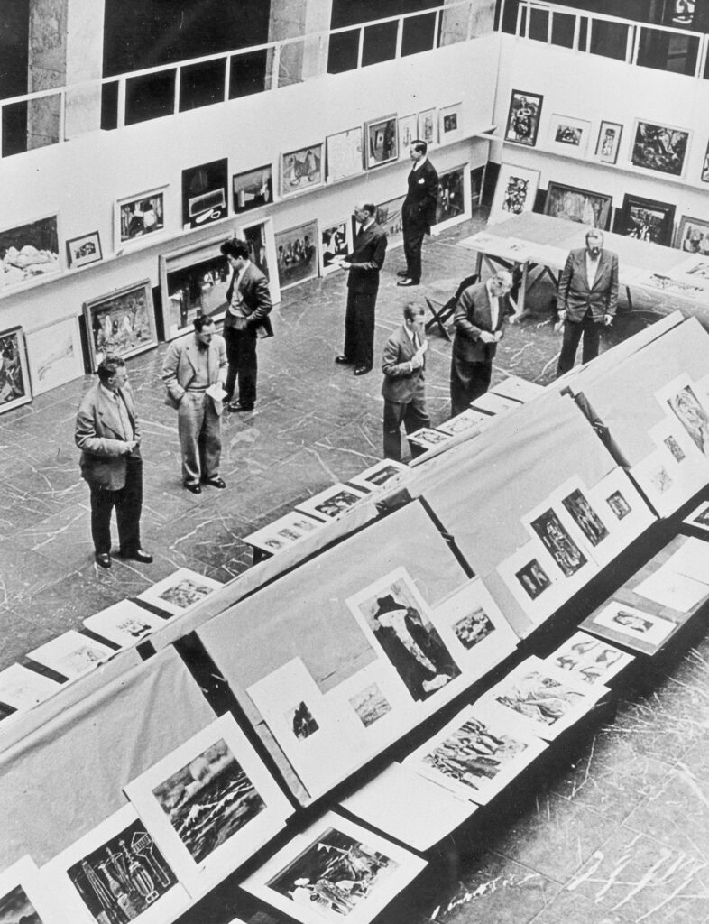 Jury betrachtet ausgestellte Kunstwerke im Central Collecting Point München